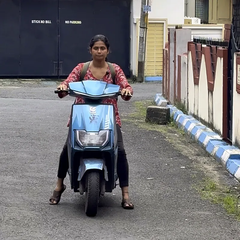 Beginner on her first scooty ride with feet ready on the ground