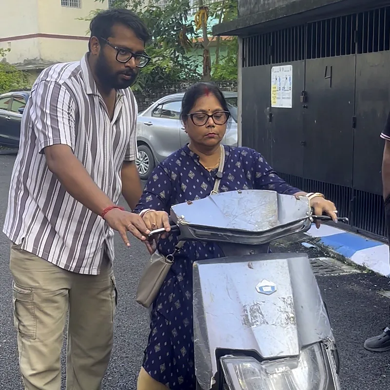 Trainer guiding a learner's hand on the scooty throttle